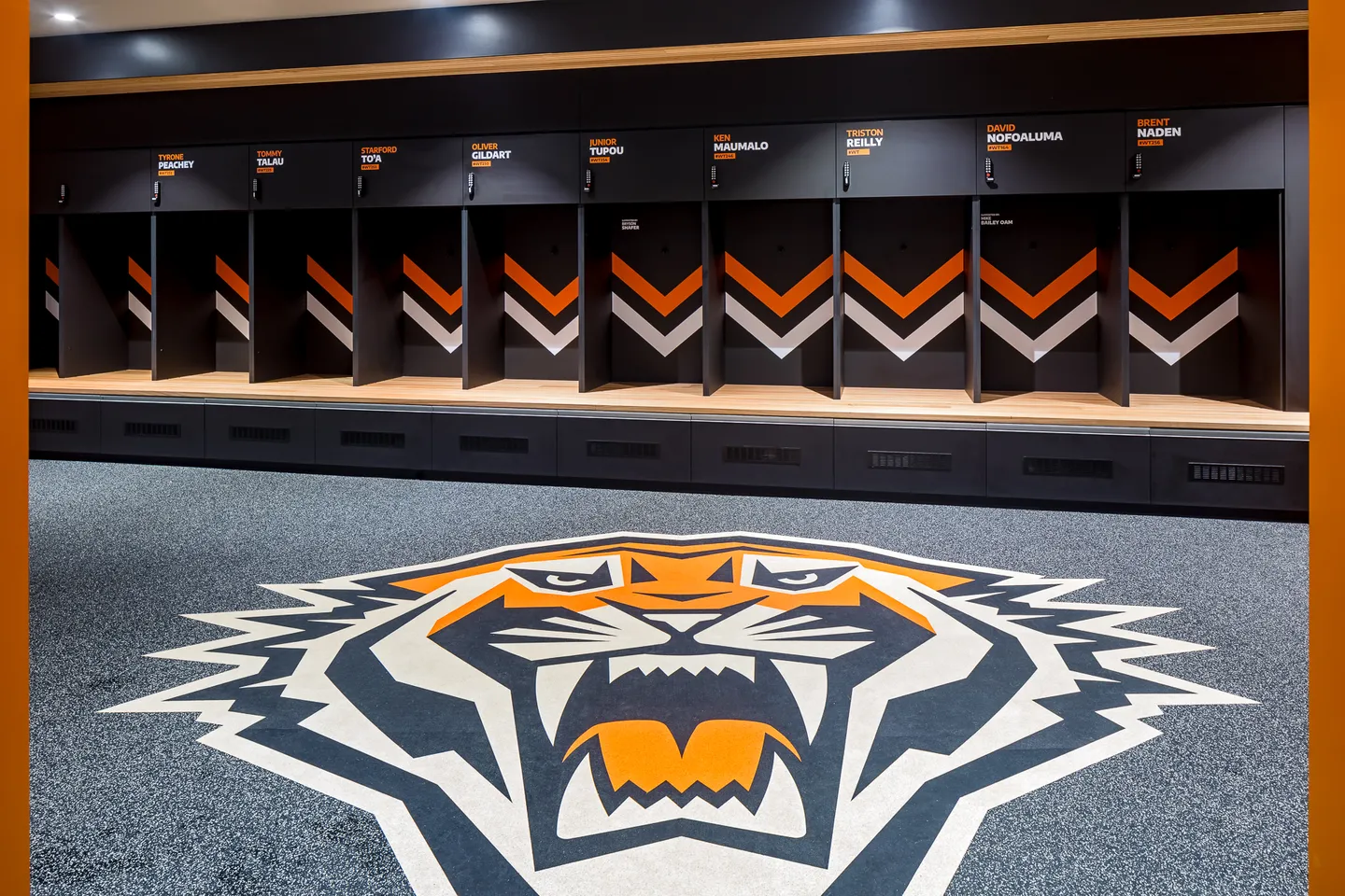 Team locker room with custom joinery and Tigers floor emblem — West Tigers Centre of Excellence